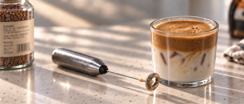 a glass of iced latte with date syrup and two dates next to the glass
